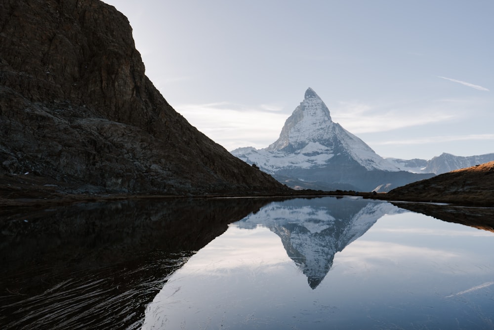 a mountain is reflected in the still water of a lake