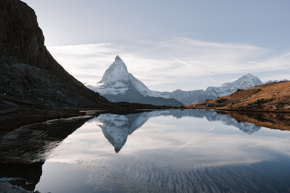 a mountain is reflected in the still water of a lake