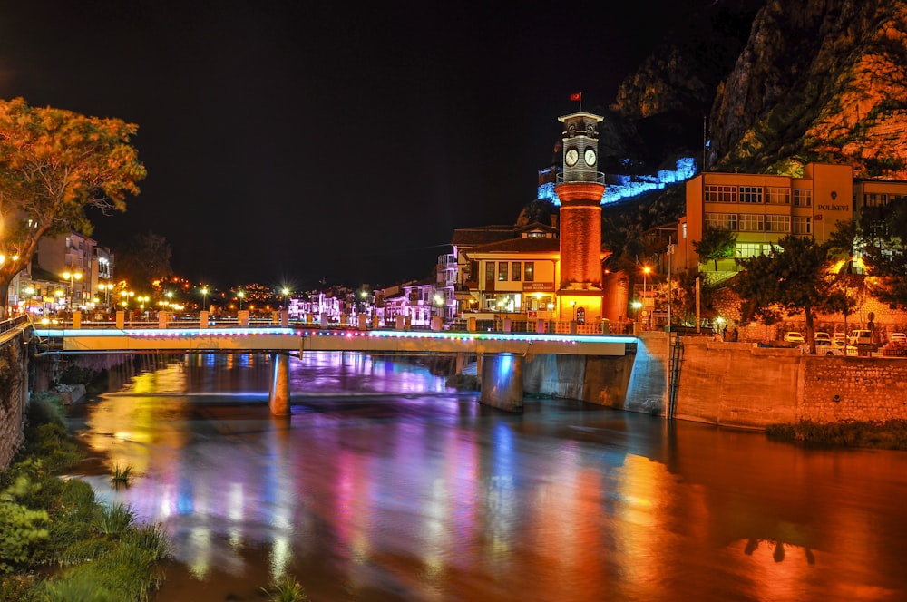 eine Brücke über einen Fluss mit einem Glockenturm im Hintergrund