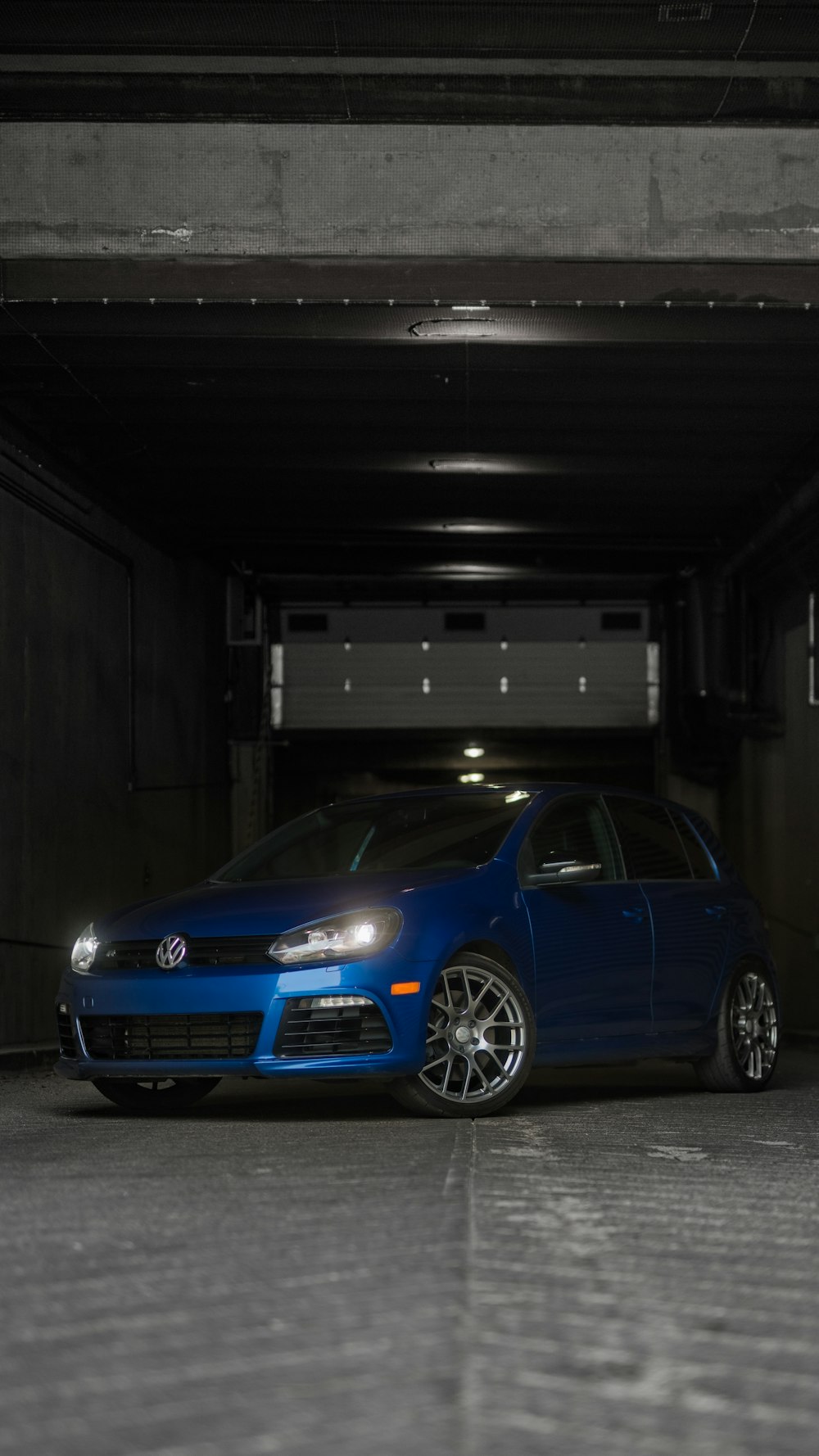 a blue car parked in a parking garage