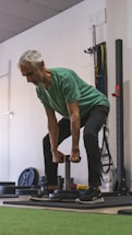 A friendly elderly man lifting weights in a gym setting.