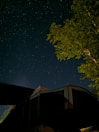 A clear night sky filled with stars above a tranquil campsite.