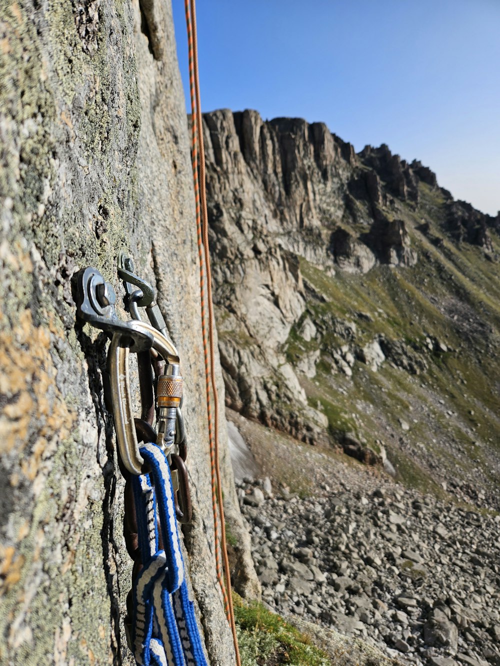a rock climber's gear hanging on the side of a mountain