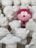 A group of sculpted figurines are gathered together, mostly in white with one prominent red and pink figure standing out. The figures appear to be cartoonish characters with varying shapes, including round and animal-like forms. They are intricately designed with different facial expressions and accessories.