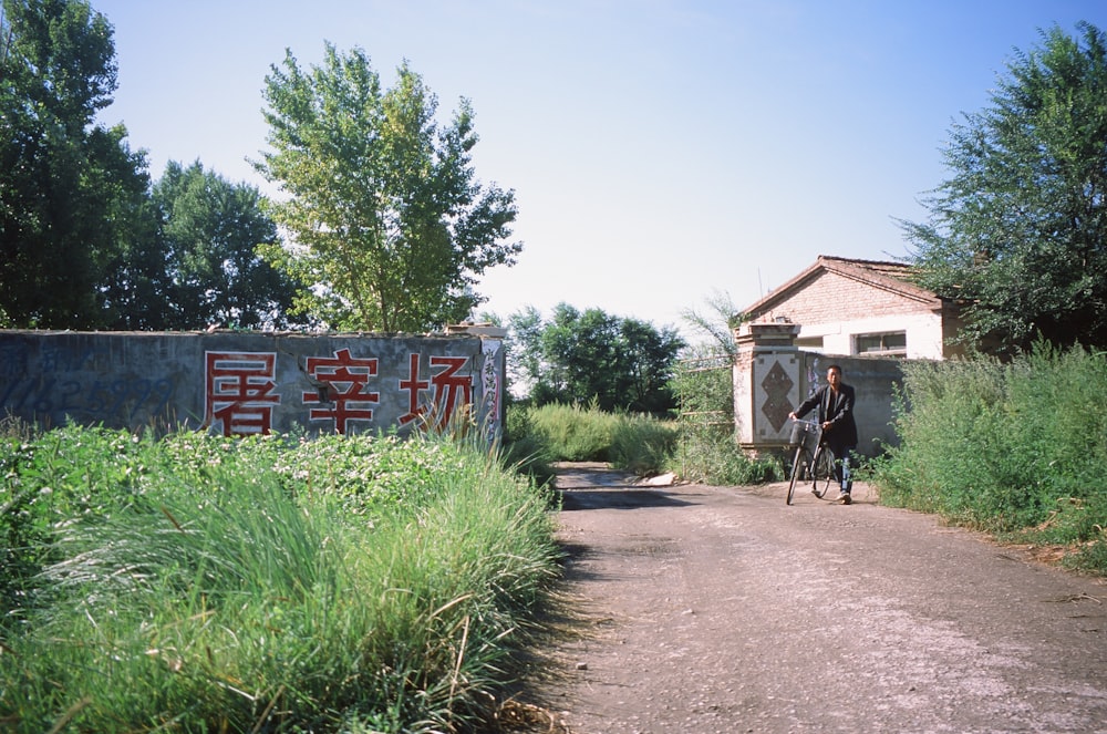 a man riding a bike down a dirt road