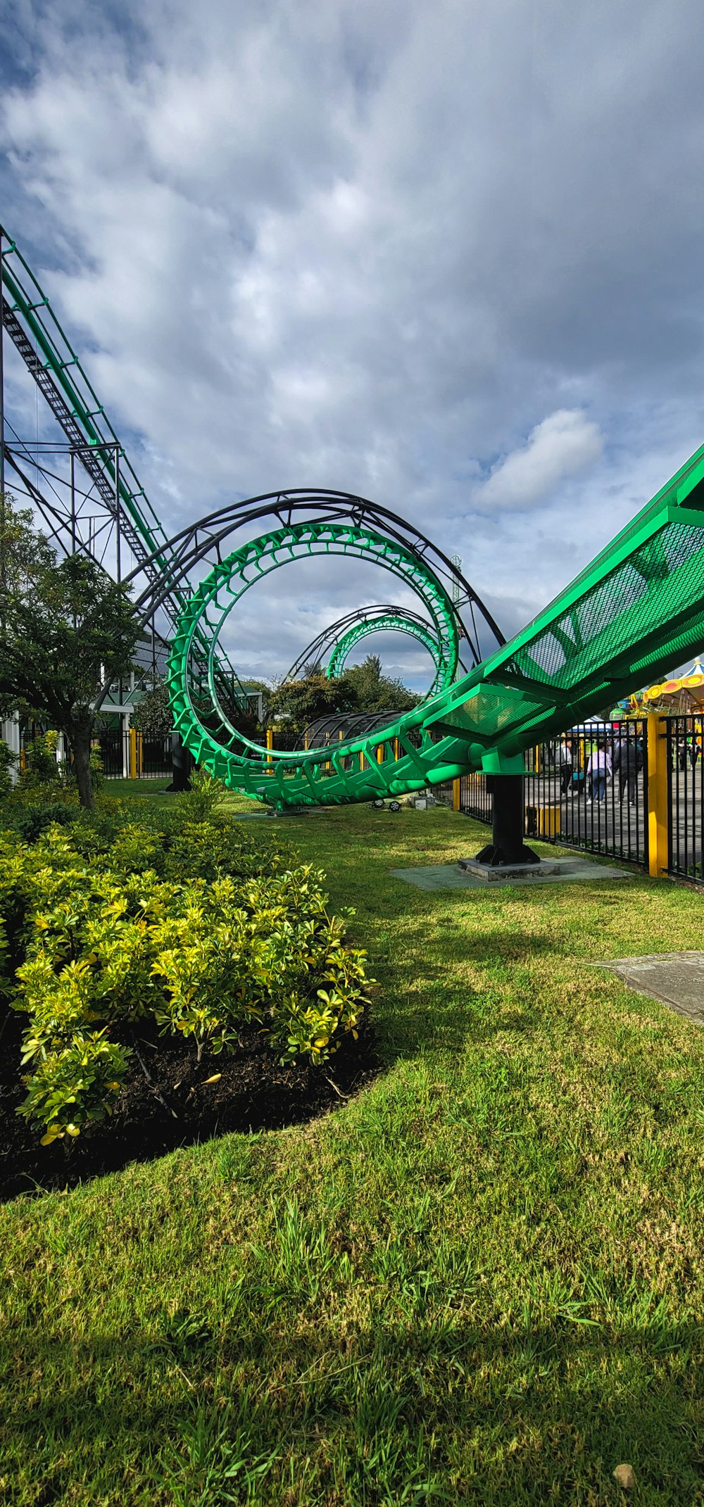 a green roller coaster going down a hill