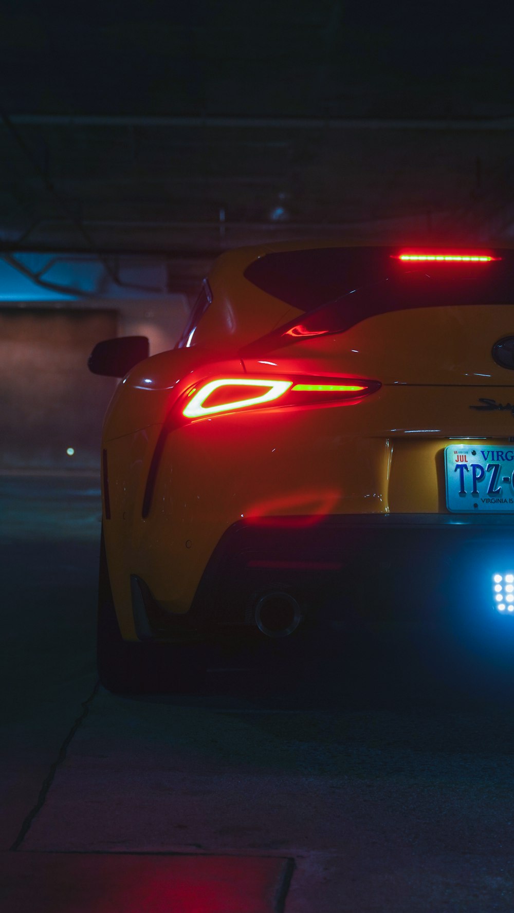 a yellow sports car parked in a parking garage