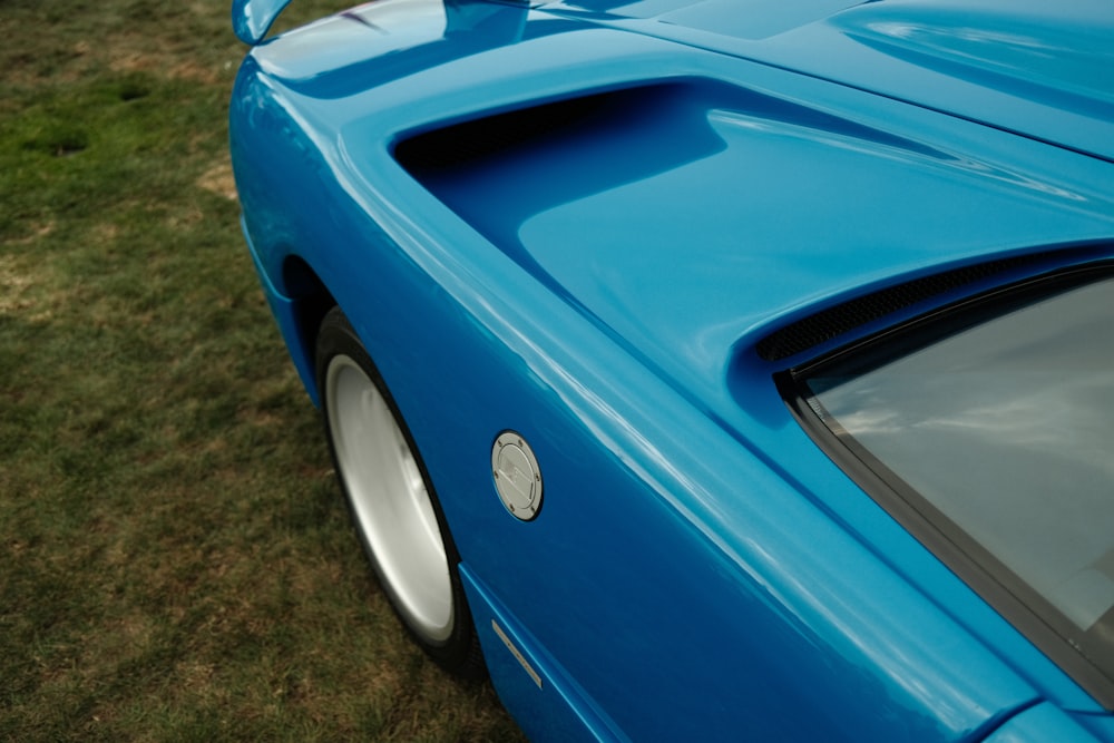 a blue sports car parked in a grassy field