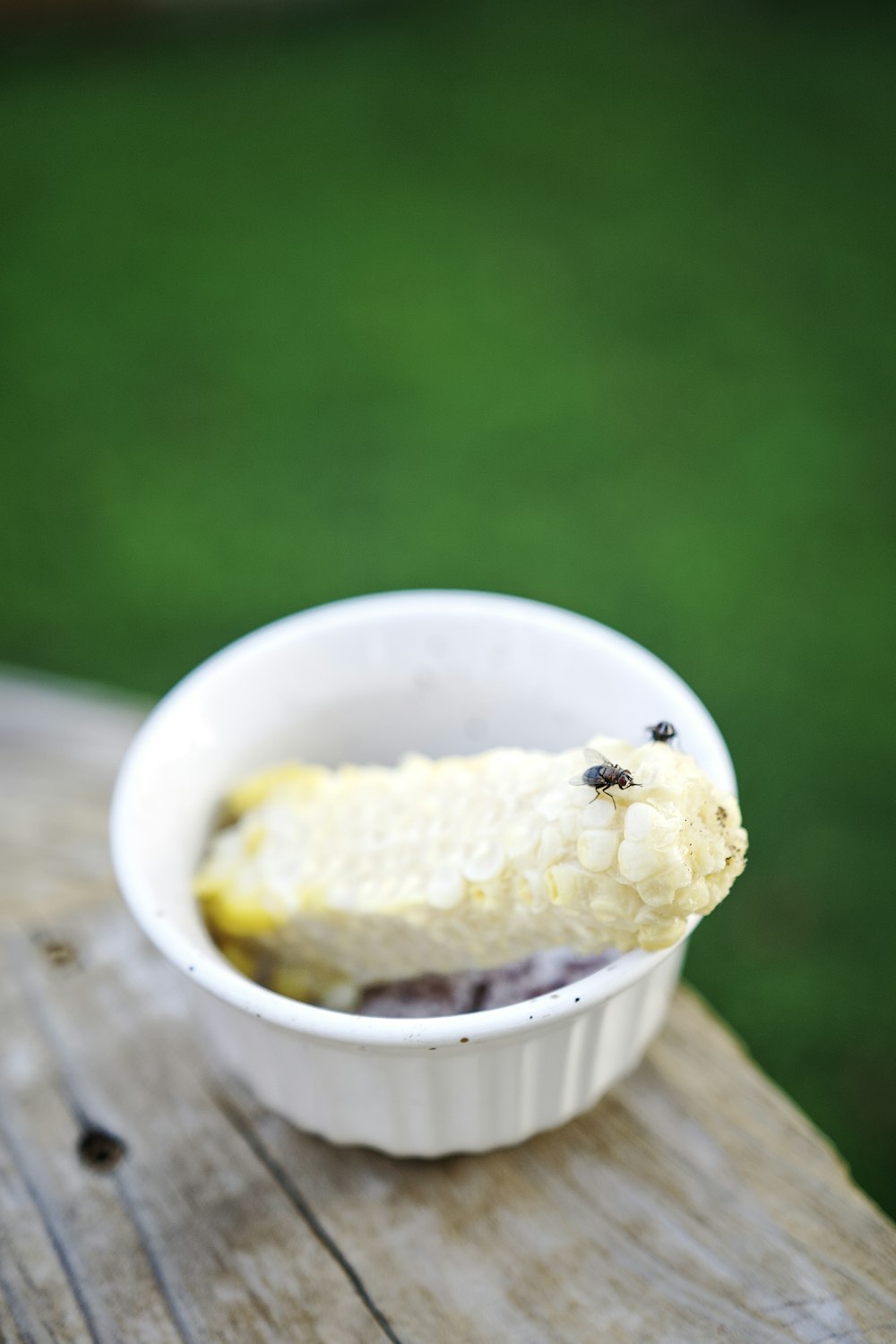 a white bowl filled with food on top of a wooden table