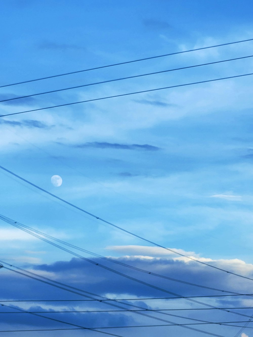 power lines and telephone poles against a blue sky