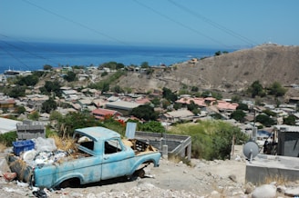 A 413junkrelief truck loaded with junk, parked in a sunny Hill Town driveway.