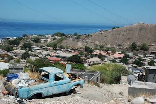 A 413junkrelief truck loaded with junk, parked in a sunny Hill Town driveway.