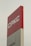 A tall sign with the letters 'CPKC' in bold white font on a red background. Below it, there is a partial view of a grey section with the text 'Vancouver'. The sign has a clean, modern appearance and stands against a cloudy sky.