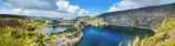 A panoramic view of a rare stone quarry nestled in the rugged Libyan landscape under a clear blue sky.