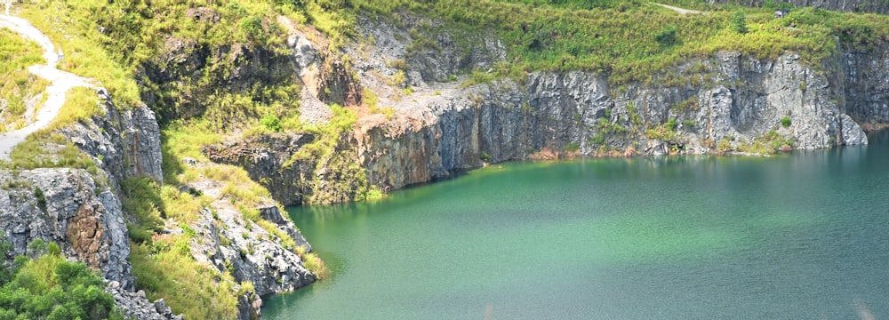 a large body of water surrounded by a lush green hillside