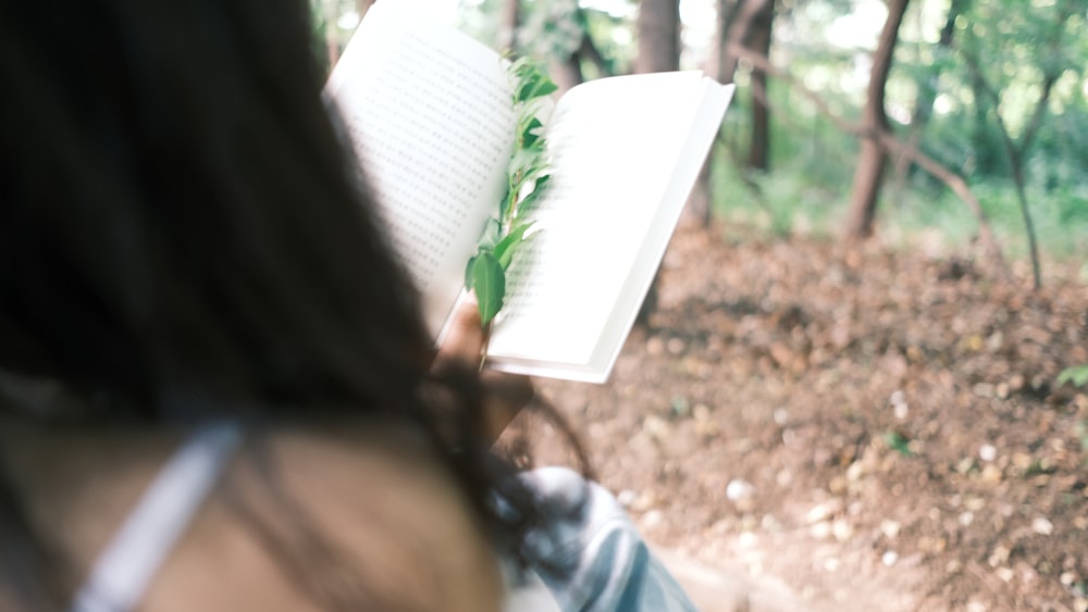 a woman reading a book in the woods