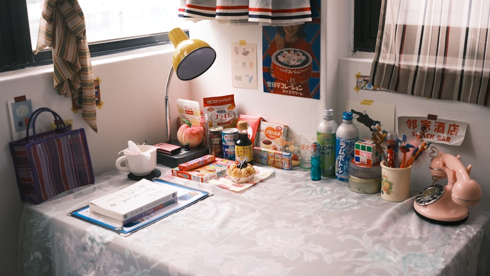 a table with a lamp, books, and other items on it