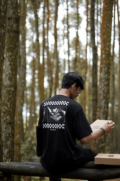 a man sitting on a bench in the woods