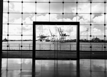 a black and white photo of a window with a view of a harbor