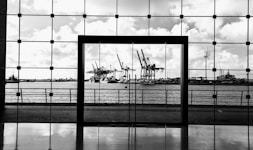 a black and white photo of a window with a view of a harbor