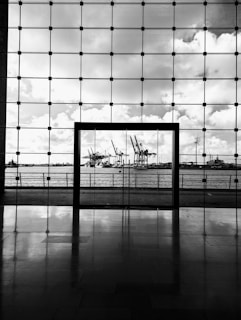 a black and white photo of a window with a view of a harbor