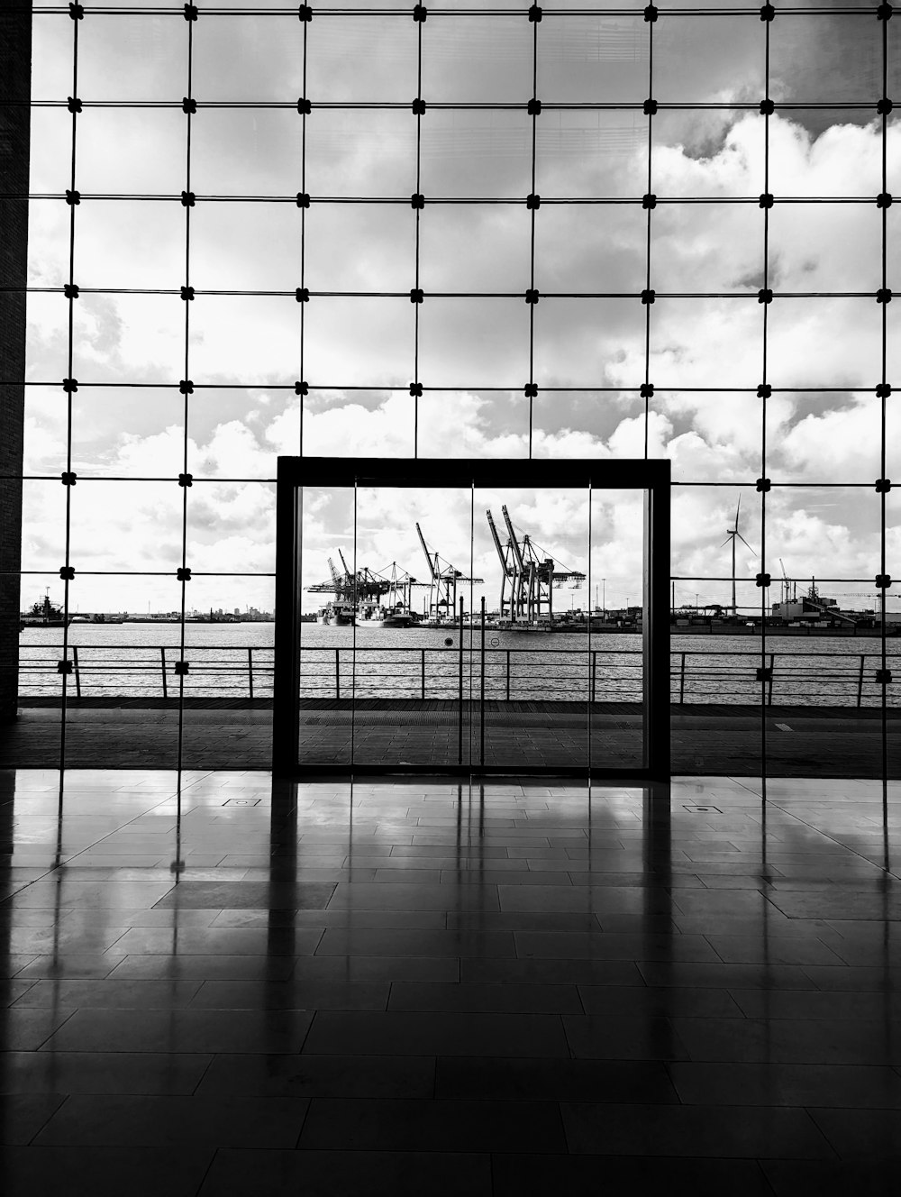 Une photo en noir et blanc d’une fenêtre avec vue sur un port