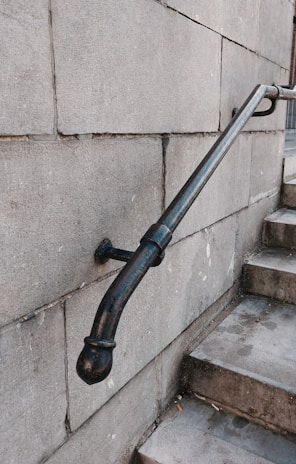 Close-up of a sturdy metal handrail with earth-tone paint.