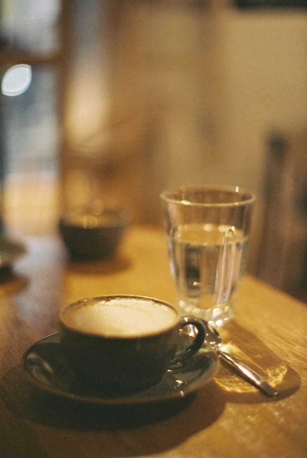 a cup of coffee sitting on top of a wooden table