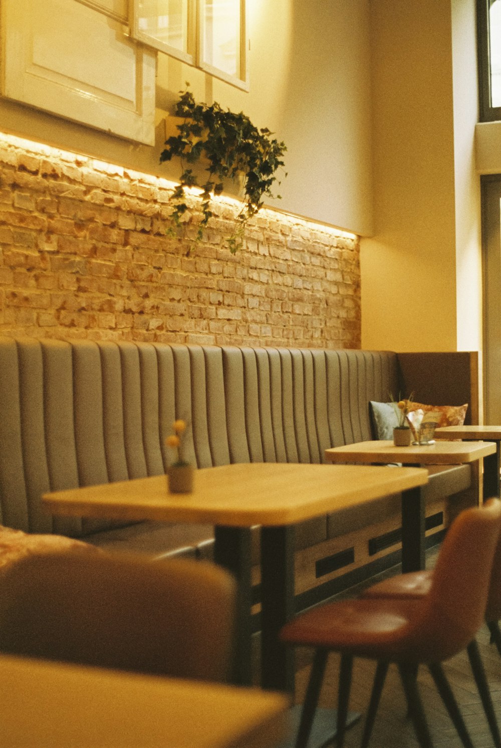 a restaurant with tables and chairs and a brick wall