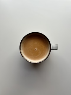 a cup of coffee sitting on top of a table