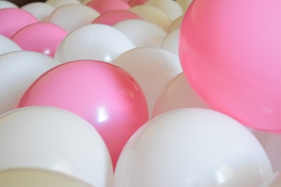 Close-up of delicate balloon clusters shaped like baby toys and stars.