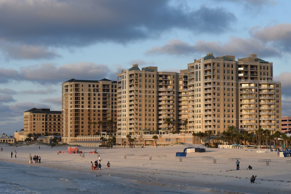 a group of people standing on top of a sandy beach