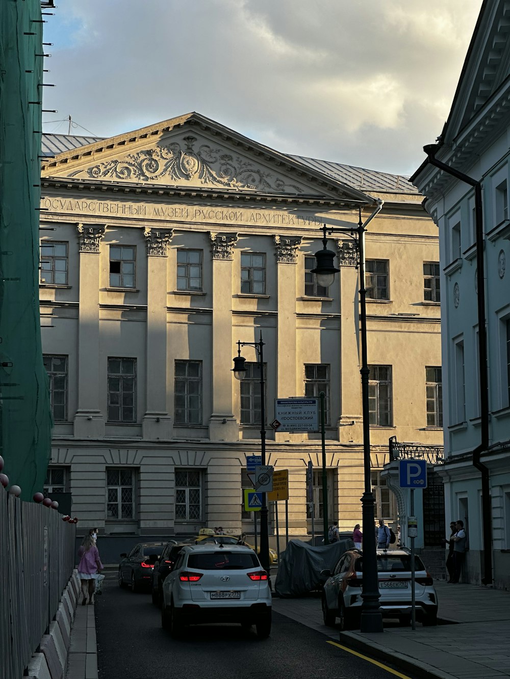 a city street filled with lots of traffic next to tall buildings