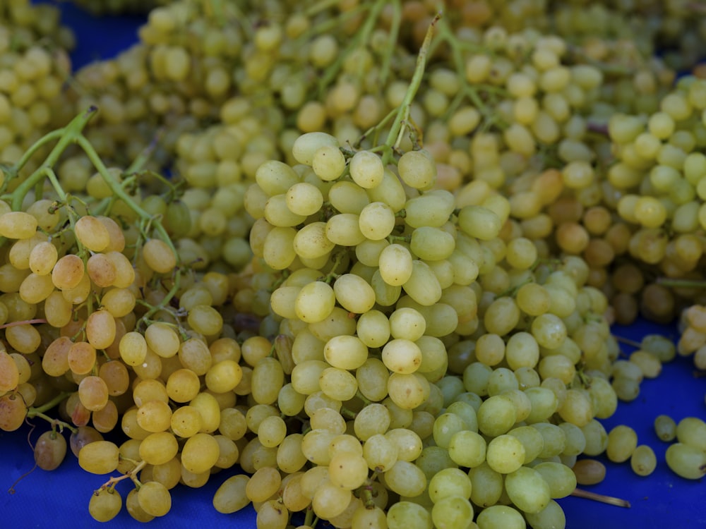 Un racimo de uvas sentado encima de una mesa azul