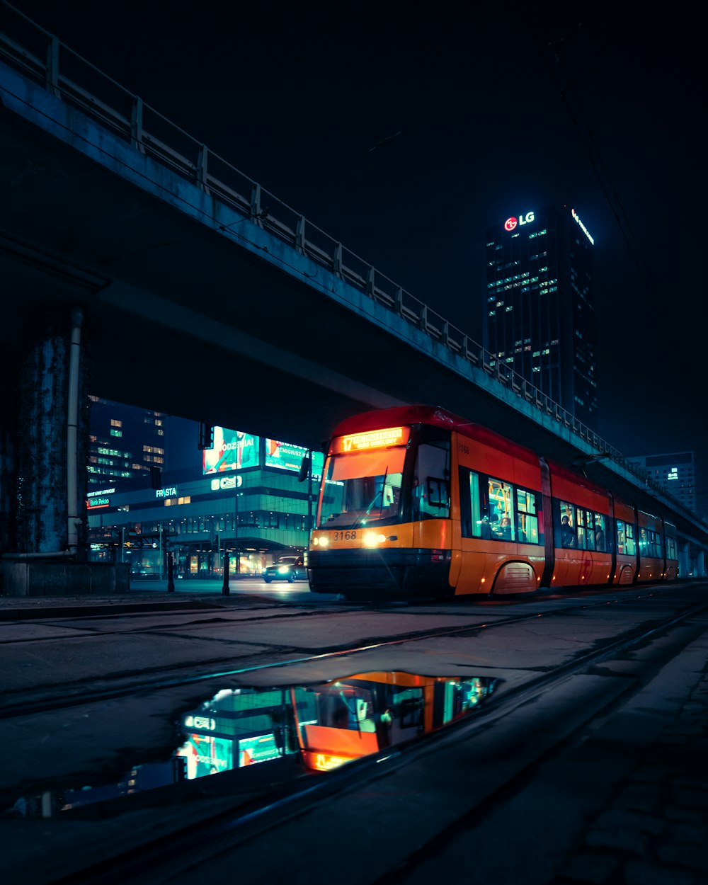 a red train traveling down train tracks next to a bridge