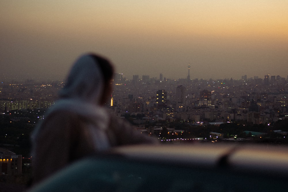 a woman in a bathrobe looking out over a city