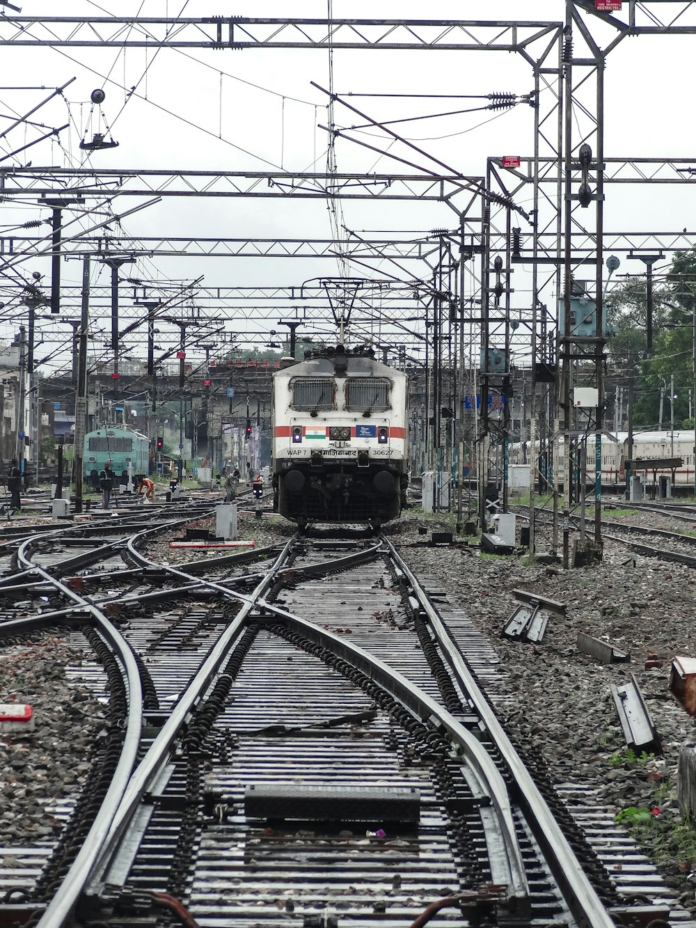 a train traveling down train tracks next to a forest