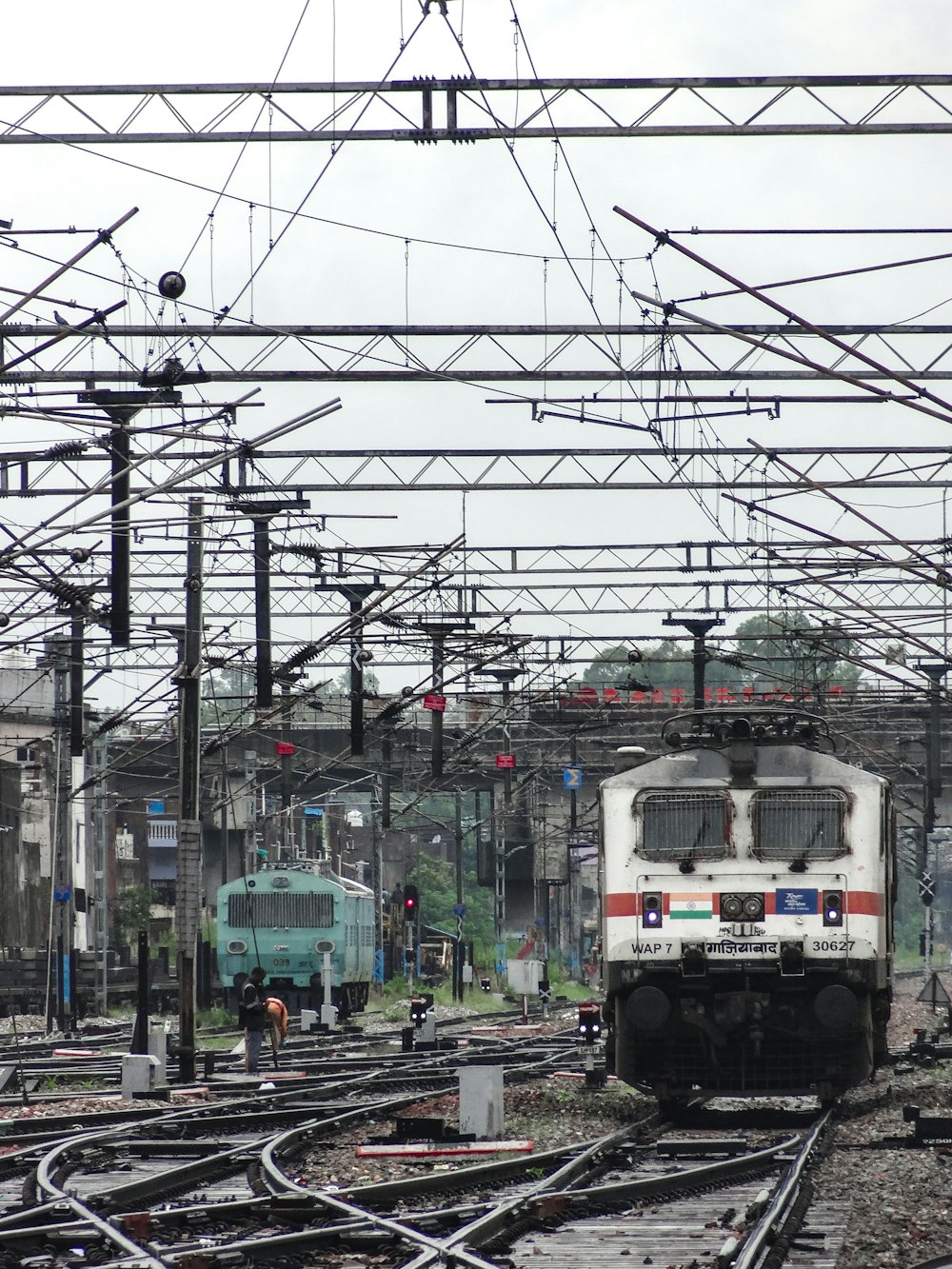 a white train traveling down train tracks under power lines