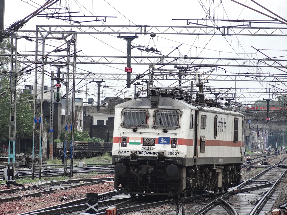 a train traveling down train tracks next to a forest