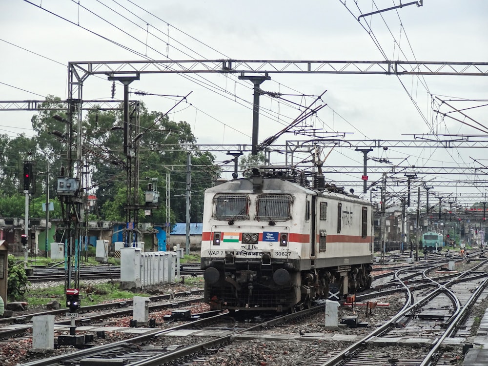 a train traveling down train tracks next to a forest