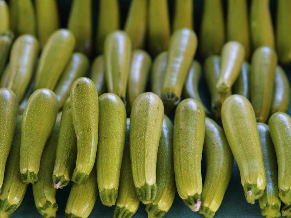 a bunch of green cucumbers sitting next to each other