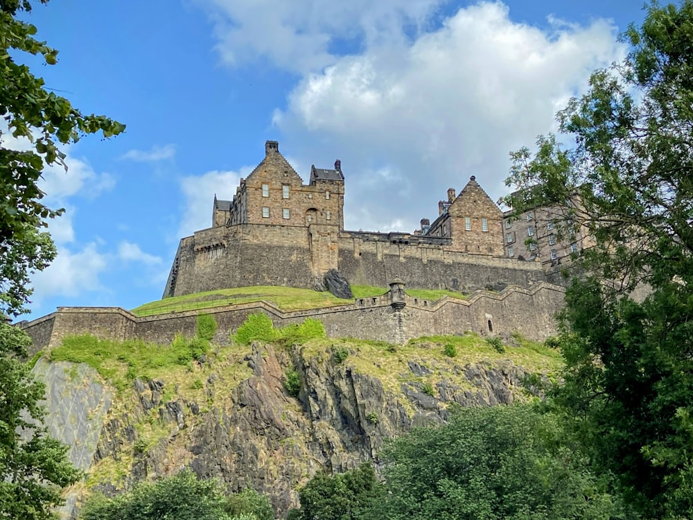 a castle on top of a hill surrounded by trees