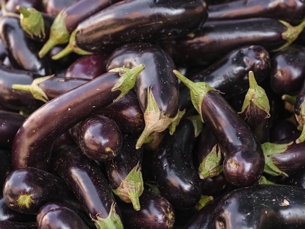 Vibrant green aubergines arranged on a rustic wooden table.