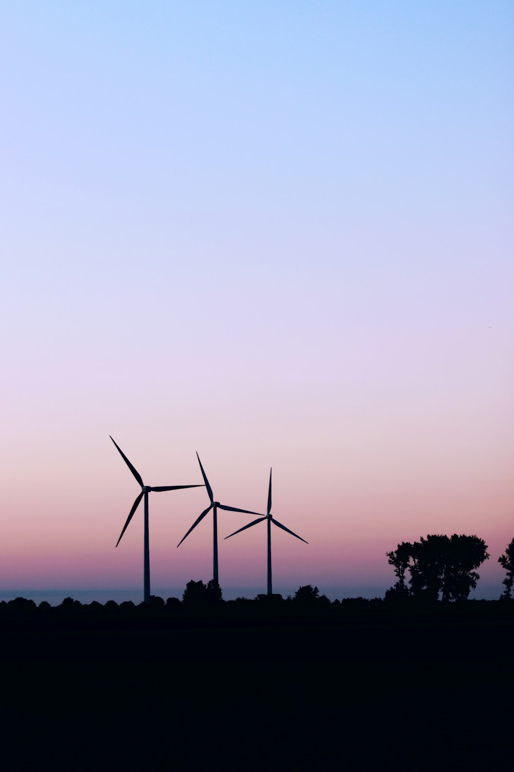 a couple of windmills that are standing in the grass