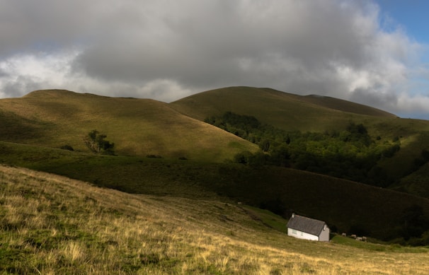 Valley View cottage exterior with panoramic views of rolling green valleys under a cloudy sky.