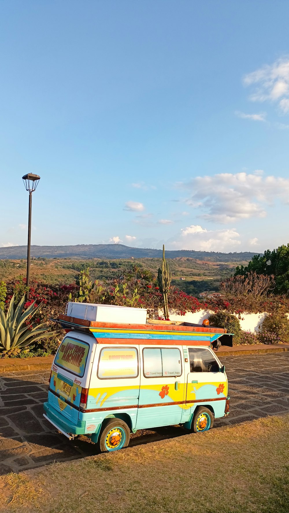 a van parked on the side of a road with a surfboard on top of