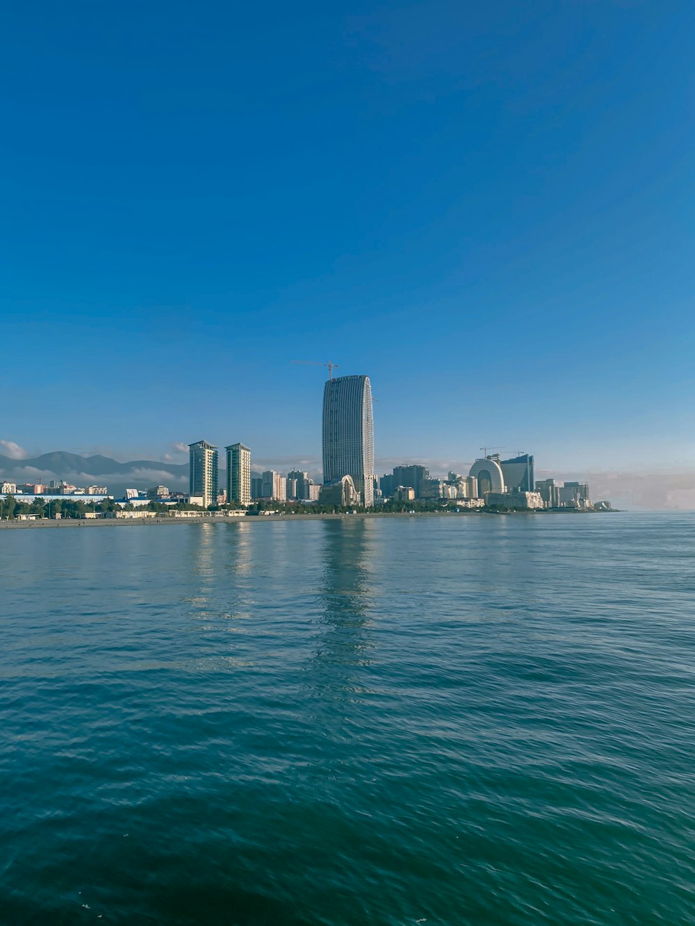 a large body of water with a city in the background