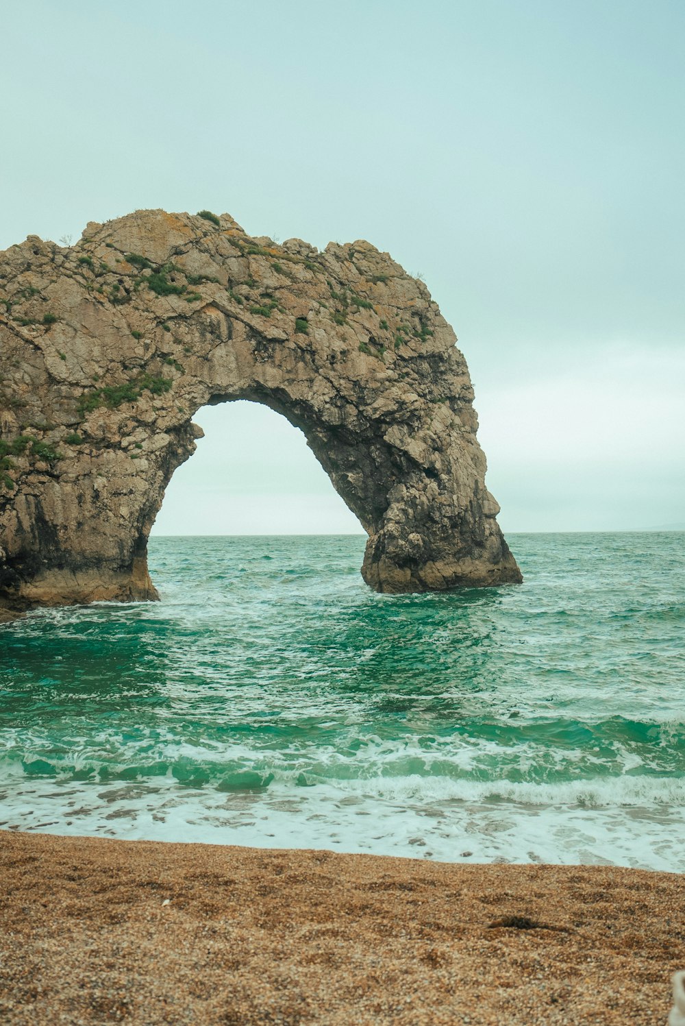 a large rock formation in the middle of the ocean