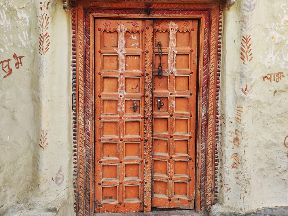 a large wooden door with carvings on the side of a building