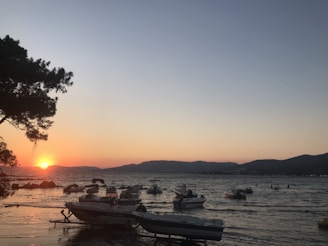 A serene beach scene along the Konkani coast at sunset with fishing boats anchored nearby